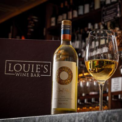 White wine bottle beside a filled wine glass.