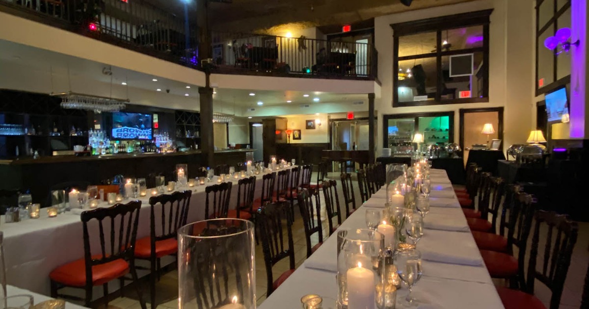 Interior, long dining tables arranged for a celebration with fine tableware and decoration