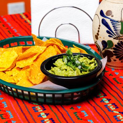 Guacamole served with tortilla chips on the side.