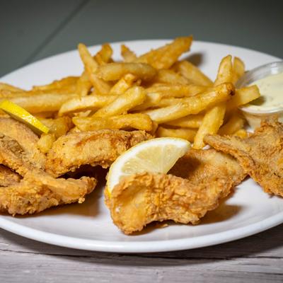 Fried cod with fries, lemon slices, and dipping sauce.