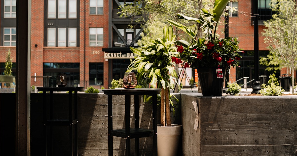 Wooden hightop table with stools and potted plants