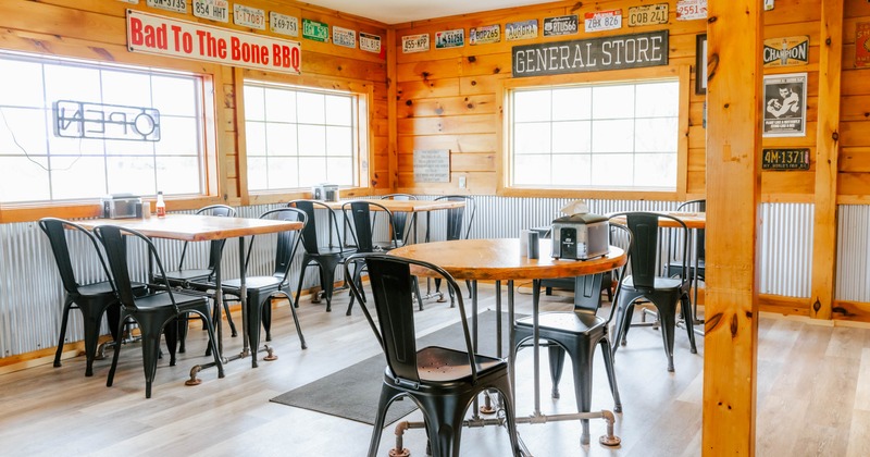 Rustic interior - wooden walls, vintage license plates, black metal chairs, wooden tables