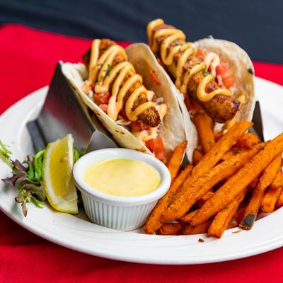 Mahi mahi tacos served with fries and dipping sauce.