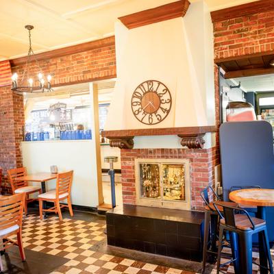 Interior space featuring a prominent white fireplace with a large metal clock.