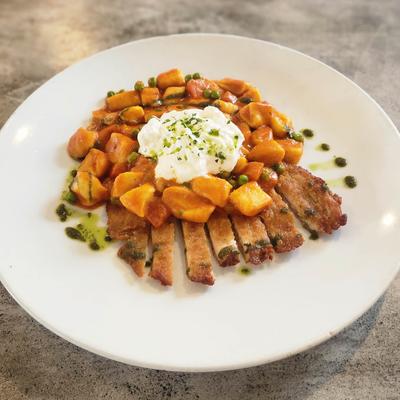 Sliced meat topped with a roasted root vegetable hash and a dollop of burrata.