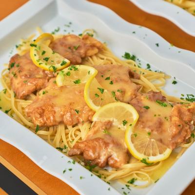 Battered chicken in lemon butter sauce on a bed of pasta.