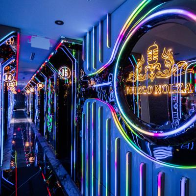 Neon hallway with reflective walls and glowing circular sign.