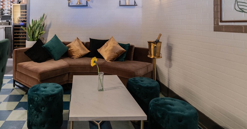 Booth with pillows, table and stools