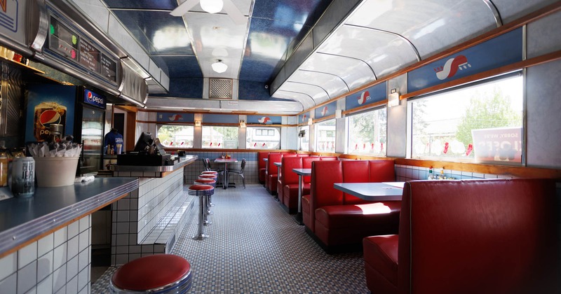 Interior, bar area, bar and bar stools on the left, seating booths on the right