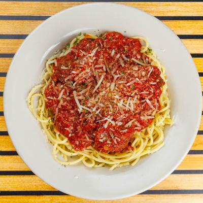 Spaghetti and Meatballs with tomato sauce and grated cheese, overhead view.