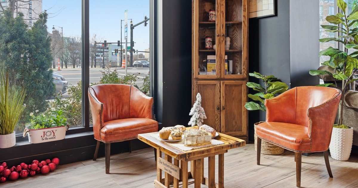 Two leather chairs with a decorated small table in the corner next to large window