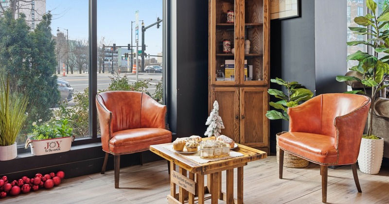 Two leather chairs with a decorated small table in the corner next to large window