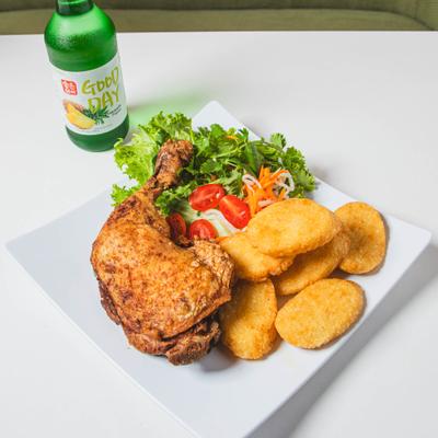 A plate of fried chicken with potato nuggets and a fresh green salad.
