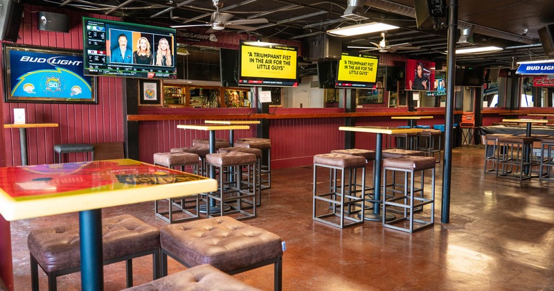 Interior, seating area with high tables and cushioned chairs