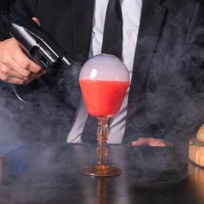 Red cocktail with a bubble filled with smoke.