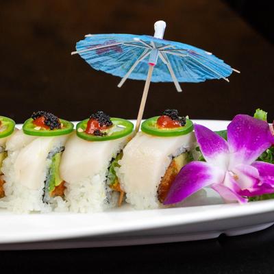 Spicy salmon and avocado sushi rolls, topped with jalapenos, and black roe.