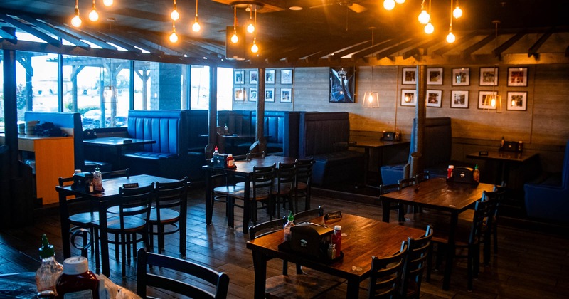Interior, seating area with tables, chairs and booths in the back