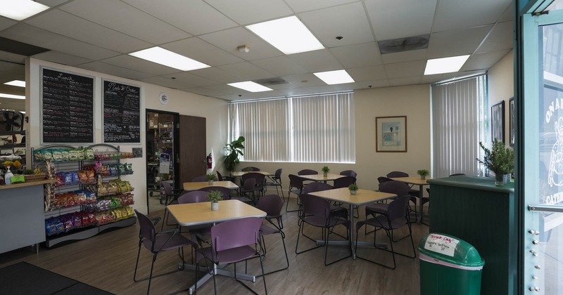 Interior, dining area, tables and chairs ready for guests, snacks stand, menu boards