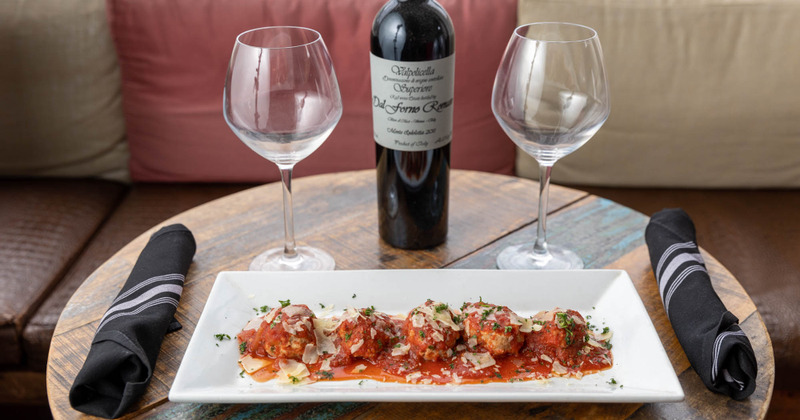 Veal and pork meatballs, served in tomato gravy, two glasses of wine and a bottle