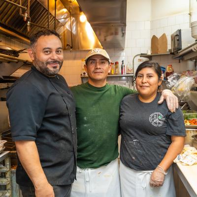Kitchen staff posing together in the kitchen.