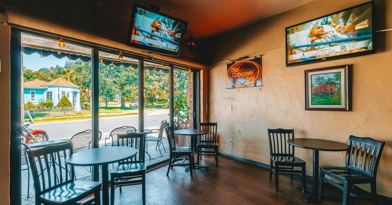 Interior, seating area by the window with TVs on the wall