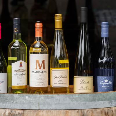 Wine selection, bottles lined up on a wooden barrel.