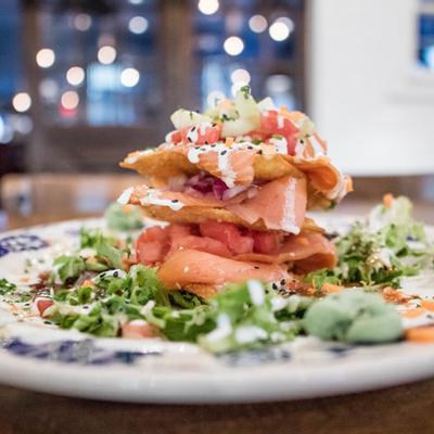 A dish with nachos and guacamoli.
