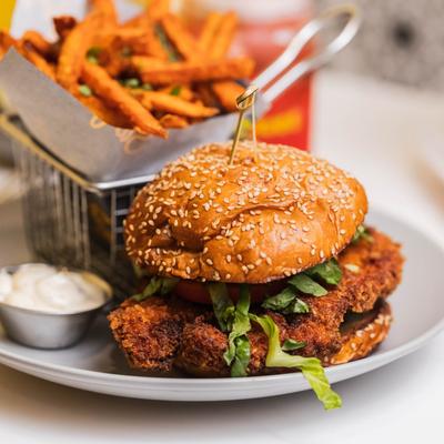 Crispy chicken sandwich with sweet potato fries and dipping sauce.