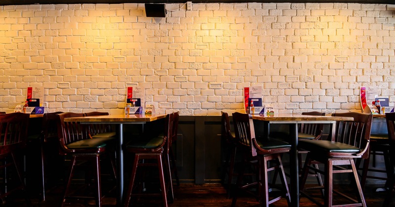 Interior, high tables and chairs near wall