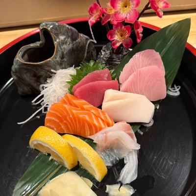Sashimi platter featuring raw salmon, tuna, yellowtail and various garnishes.