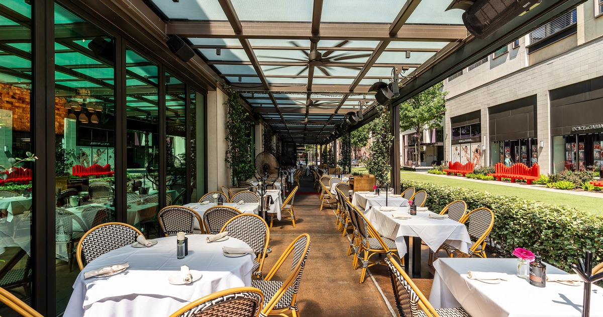 Covered and cozy outdoor dining area with tables ready for guests