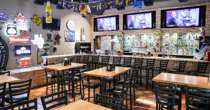 Interior, high tables and chairs with bar in the back