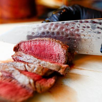 Argentinian Steak being sliced on a board, close-up.