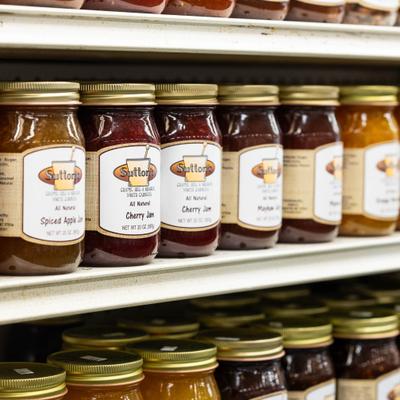 Shelf sacked with various canned condiments.