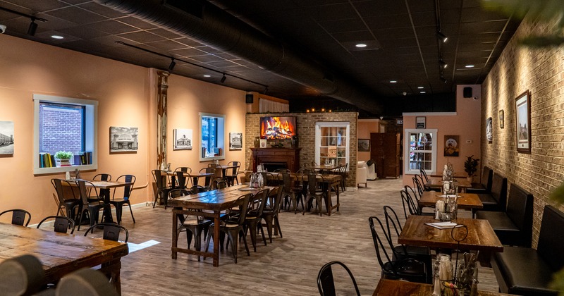 Cozy interior with wooden tables and metal chairs and upholstered bench seating along the wall