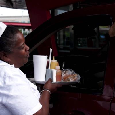 curb girl hanging tray on car.