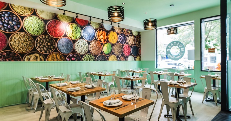 Interior, dining area with large illustration of spices on the wall