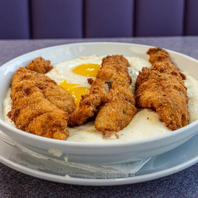 Fish and grits with two fried eggs.