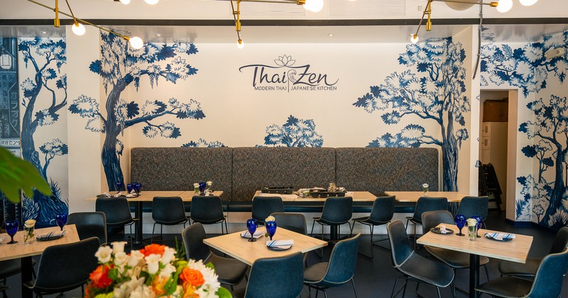 A stylish and modern interior dining area with elegant blue and white mural artwork