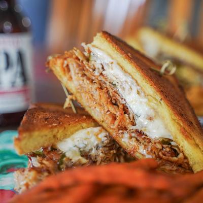 Pork sandwich with melted cheese.