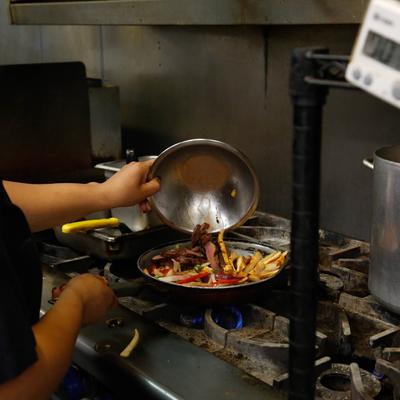 Chef frying food in a pan.