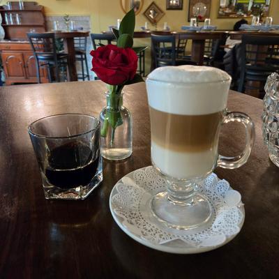 Cappuccino and a drink served on a table inside.