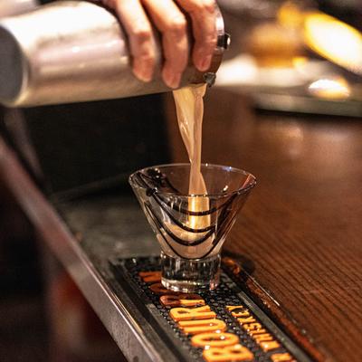 A hand pouring a cocktail.
