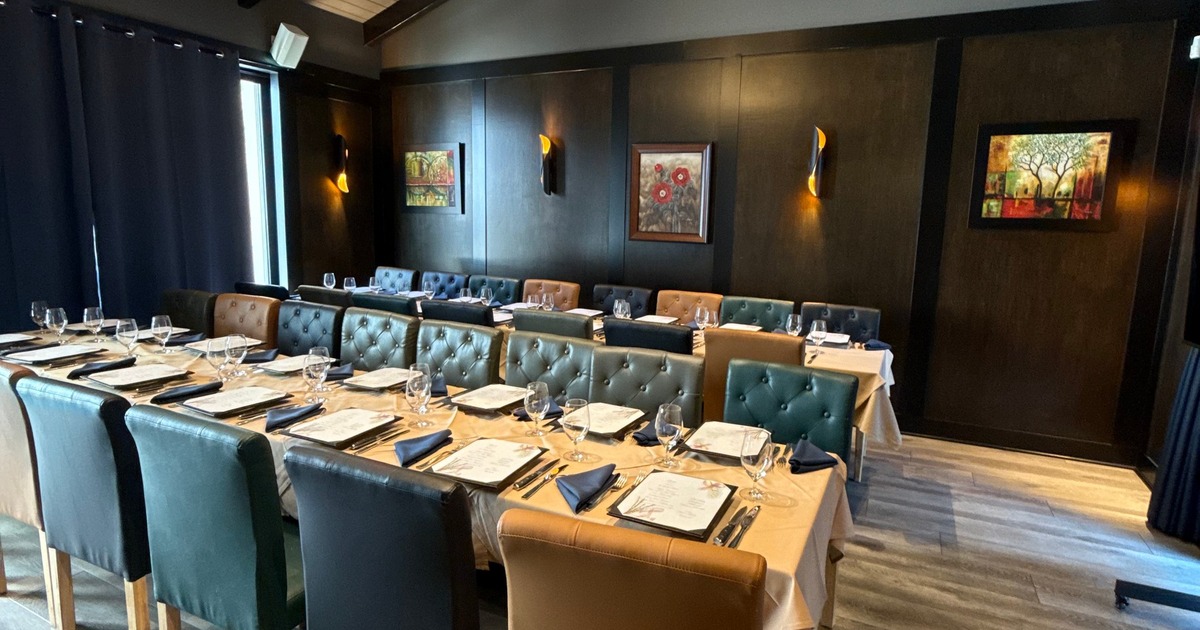 Dining Room Number One at Old Oaks Steakhouse, with banquet tables, framed art, and a glass chandelier.