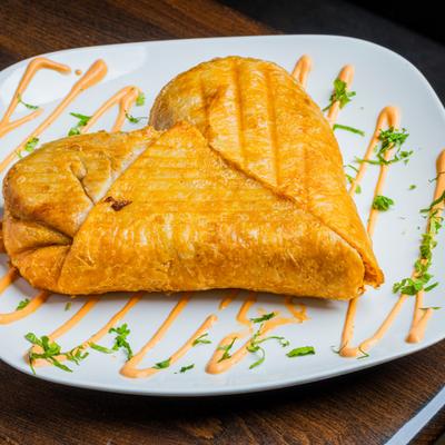 Heart-shaped chimichanga drizzled with orange sauce.