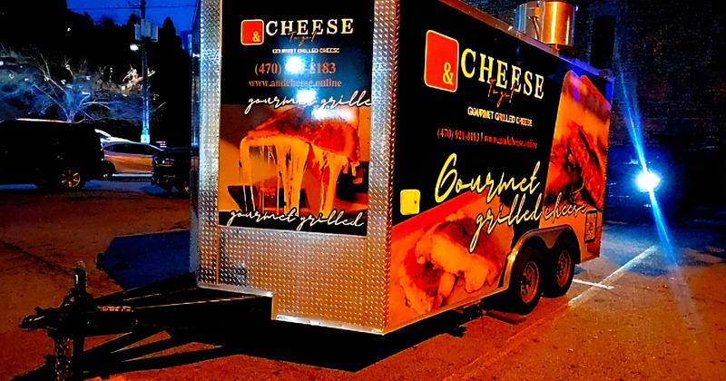 & Cheese To-Go food trailer parked on a city street at night