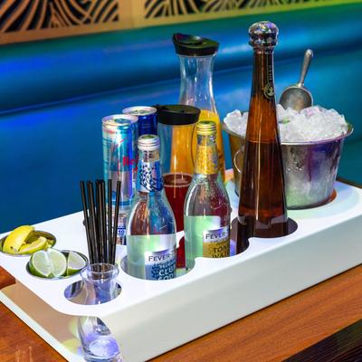 Bottle service setup with tequila, tonic water, ice, and citrus garnishes.