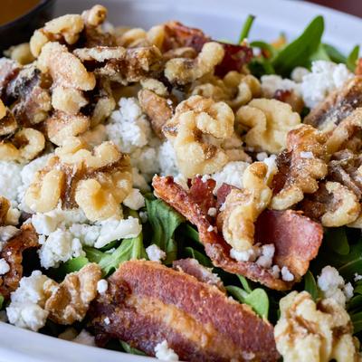 Arugula and candied bacon salad with goat cheese and walnuts.