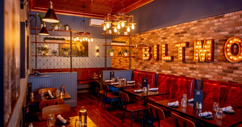 Interior featuring exposed brick walls and wooden tables set for dining.