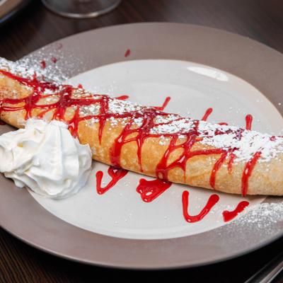 Crepe with strawberry syrup and whipped cream.